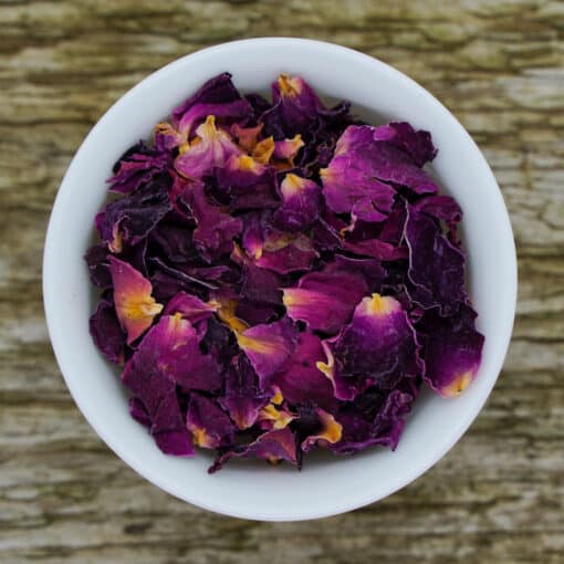 Eine Schüssel mit lila und gelben Rosenblütenblättern